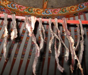 Bort -- thin strips of meat drying at the top of the yurt.